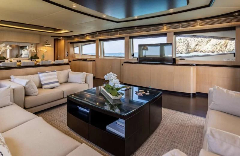 a living room with a table and couches aboard DOLCE VITA IV Yacht for Sale