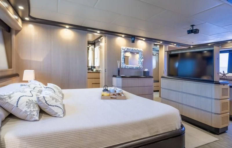 a bedroom with a bed and a television aboard DOLCE VITA IV Yacht for Sale