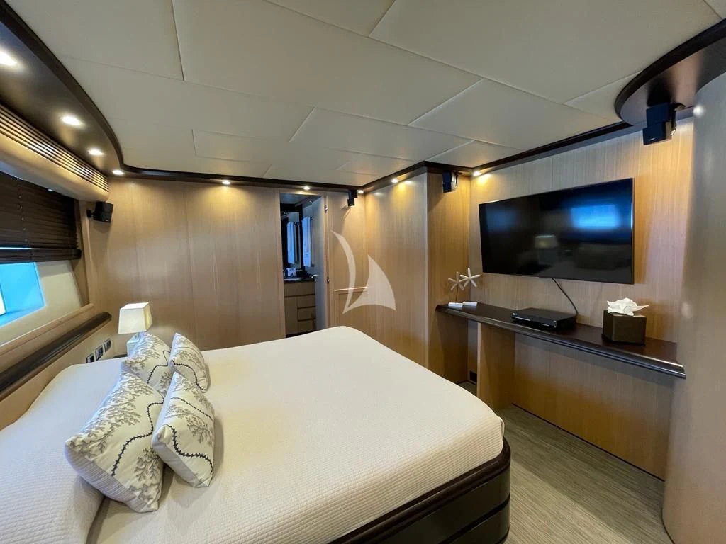 a hotel room with a bed and tv aboard DOLCE VITA IV Yacht for Sale