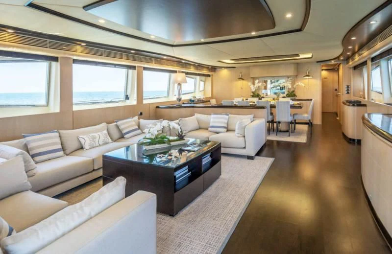 a living room with a large couch and a table aboard DOLCE VITA IV Yacht for Sale