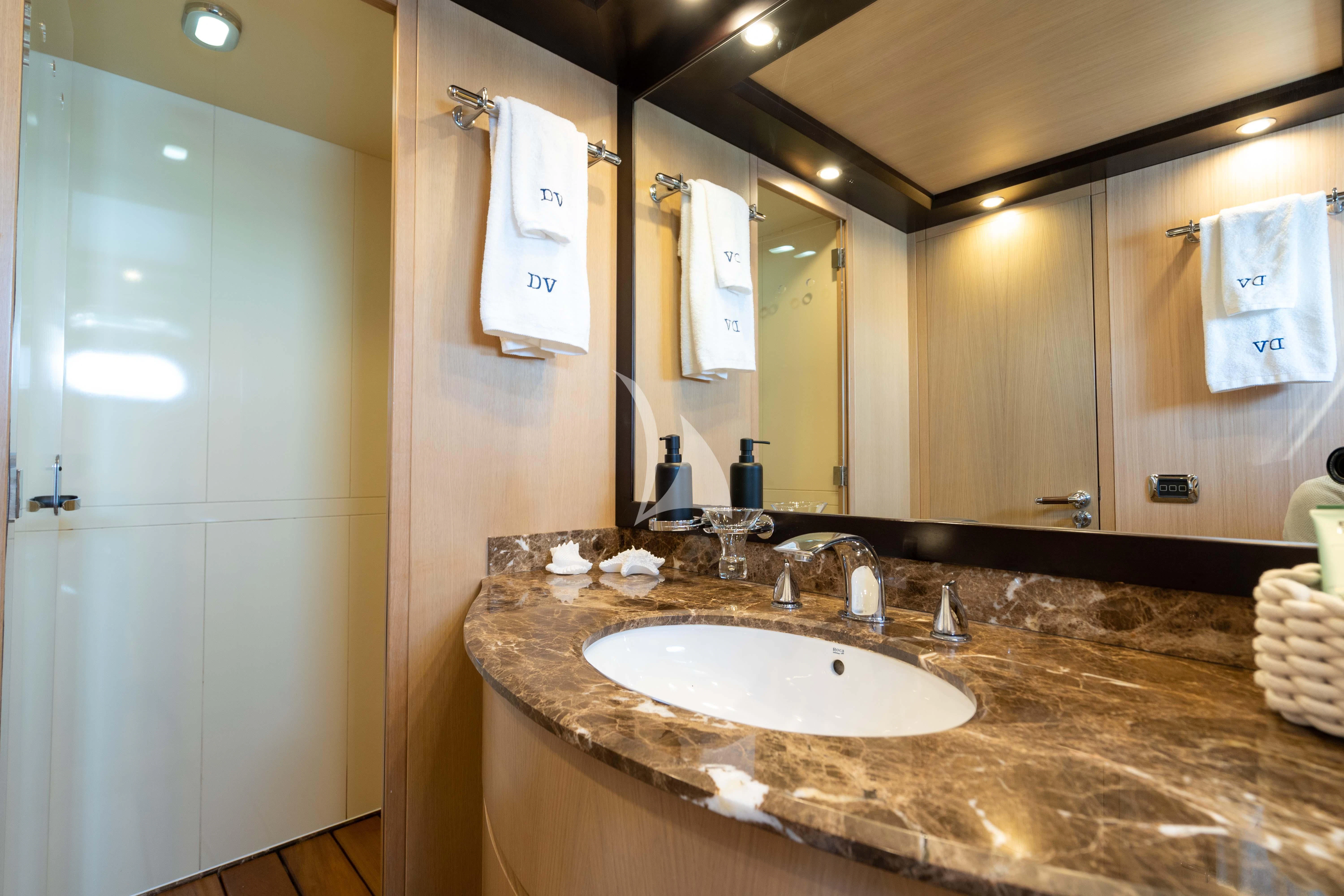 a bathroom with a countertop sink and a large mirror aboard DOLCE VITA IV Yacht for Sale