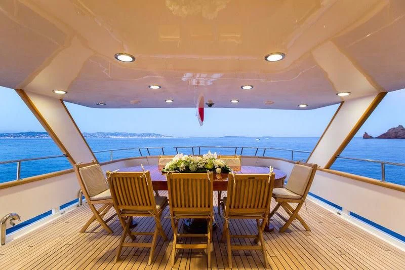 a table and chairs on a deck aboard LIBERTUS Yacht for Sale