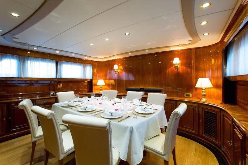 a dining room with tables and chairs aboard LIBERTUS Yacht for Sale