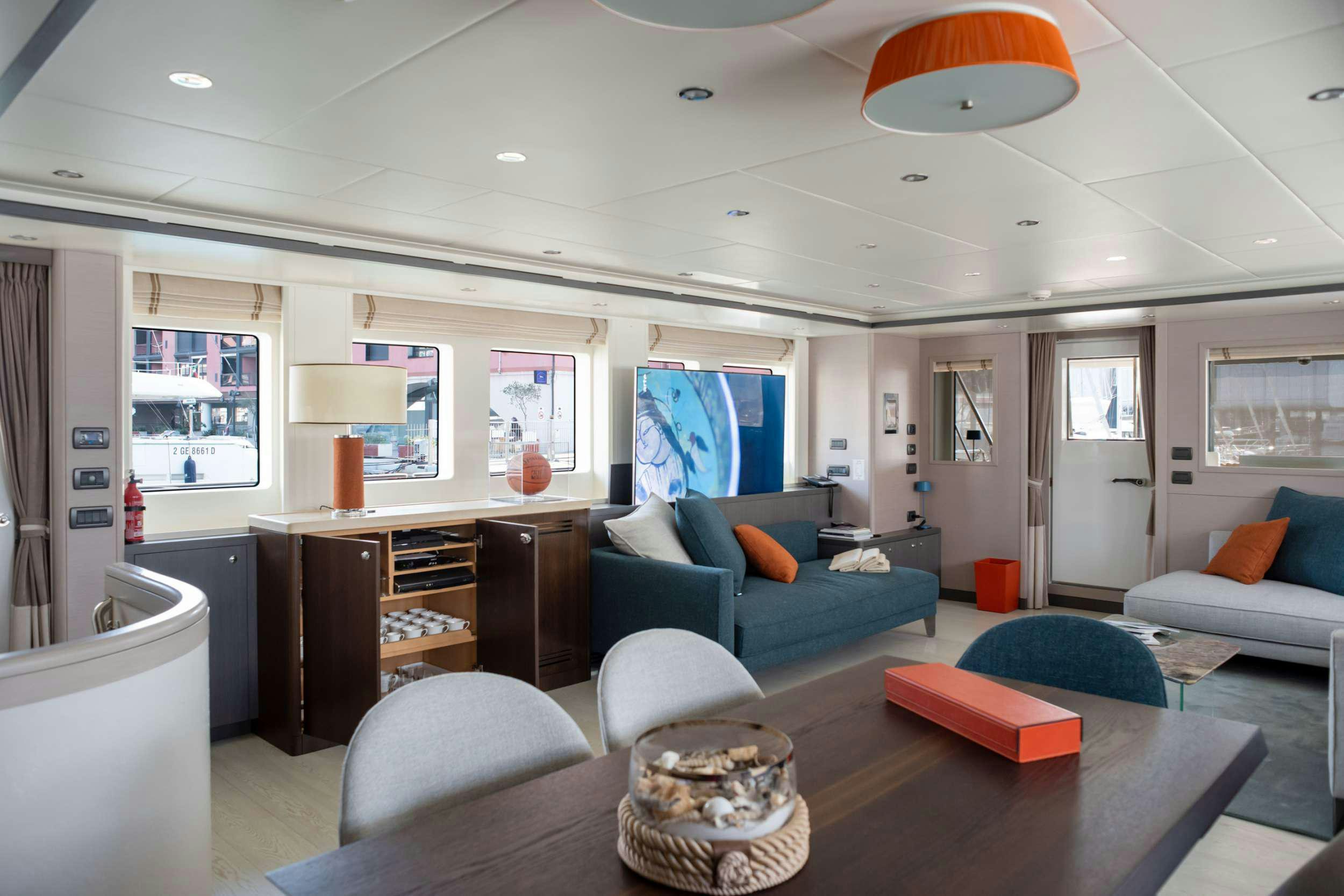 a living room with a blue couch and a table aboard GRANIL Yacht for Sale