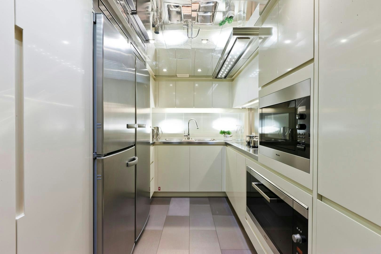 a kitchen with white cabinets aboard KUIKILA Yacht for Sale