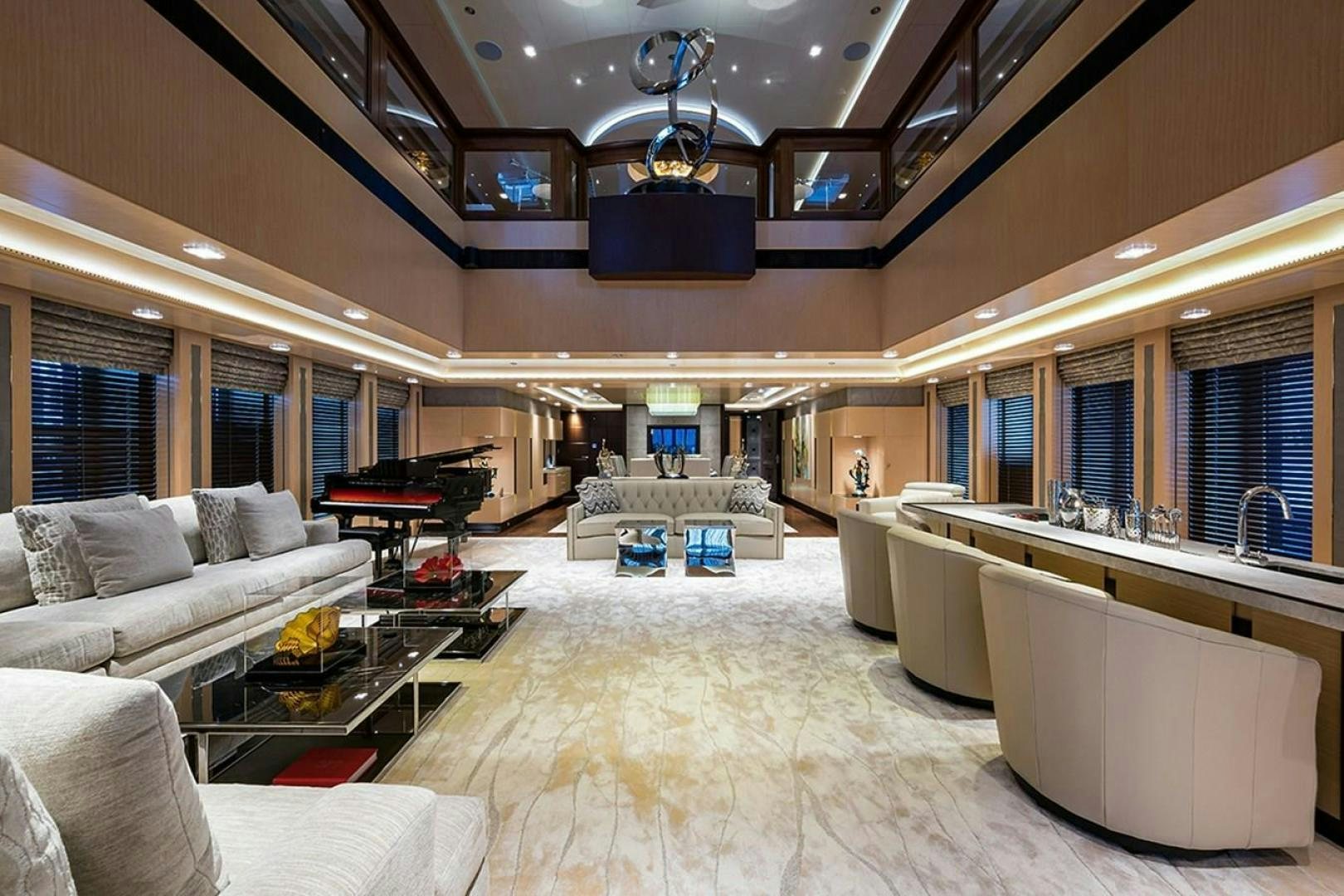 a living room with a large white couch and a large window aboard QUANTUM OF SOLACE Yacht for Sale