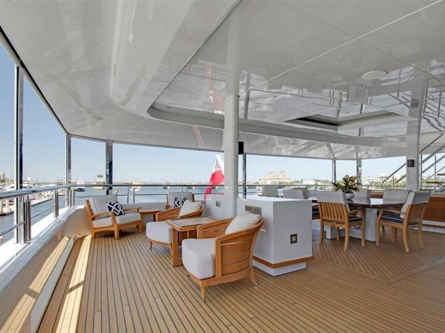a room with a wood floor and a large window with a view of the city below aboard QUANTUM OF SOLACE Yacht for Sale