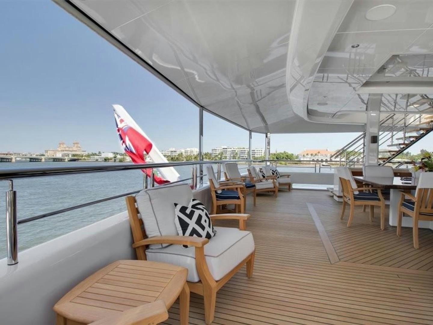 a deck with chairs and a flag on it aboard QUANTUM OF SOLACE Yacht for Sale