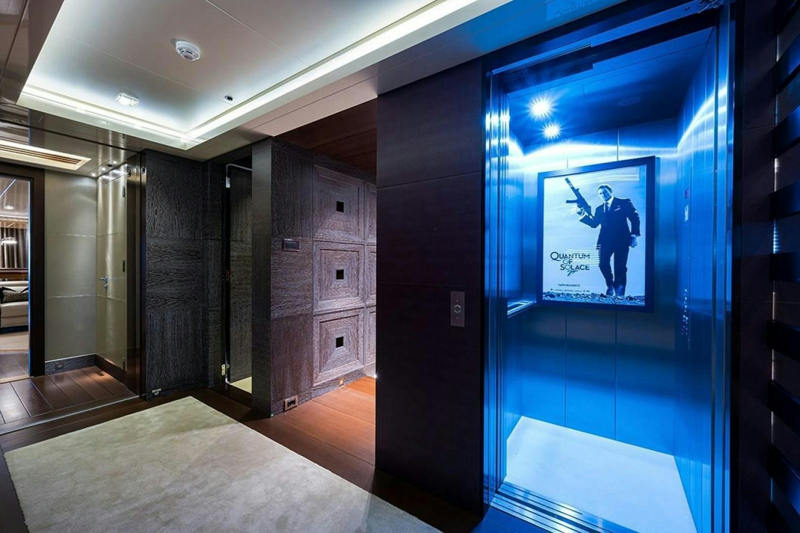a hallway with a screen and a picture on the wall aboard QUANTUM OF SOLACE Yacht for Sale