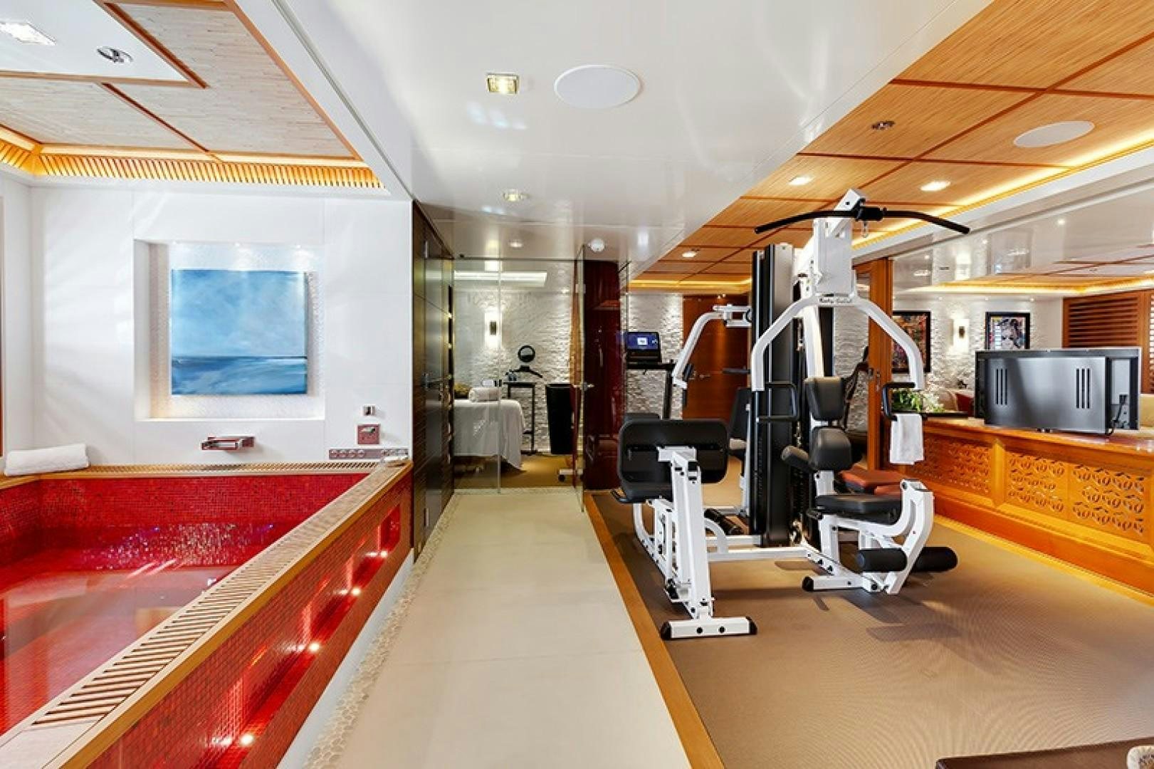 a room with a large red and white gym with equipment and equipment aboard QUANTUM OF SOLACE Yacht for Sale