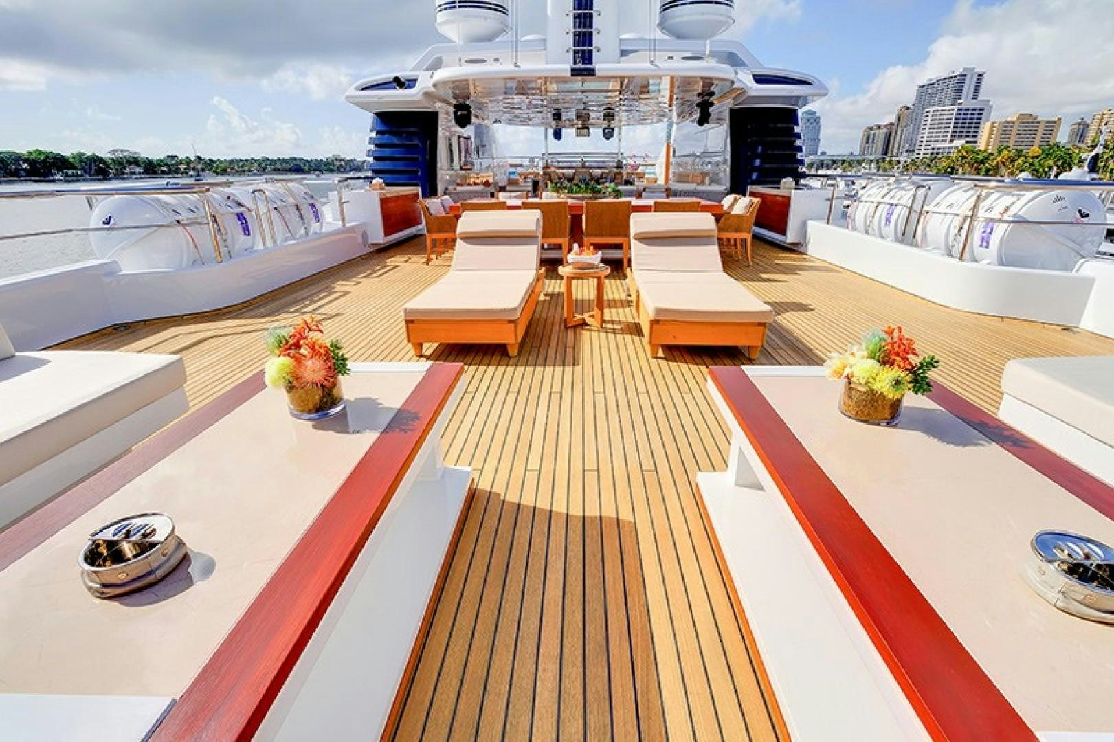 a deck with a table and chairs on it aboard QUANTUM OF SOLACE Yacht for Sale