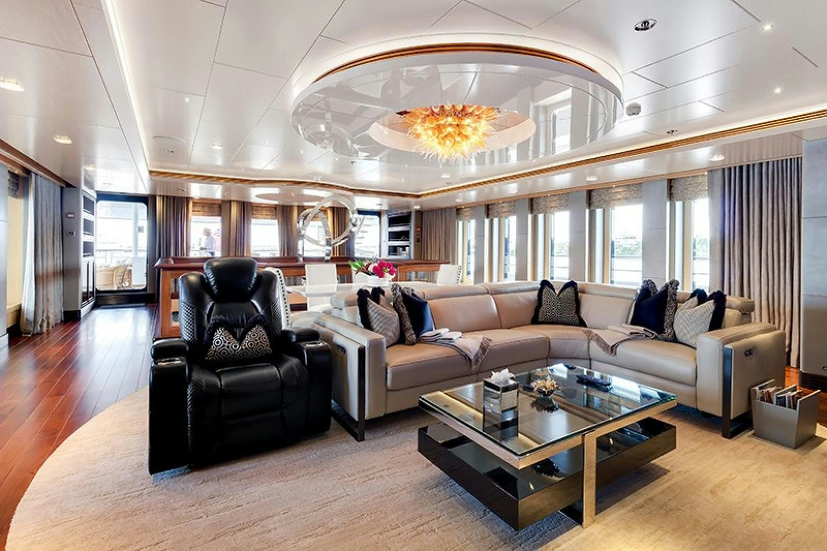 a living room with a large chandelier aboard QUANTUM OF SOLACE Yacht for Sale
