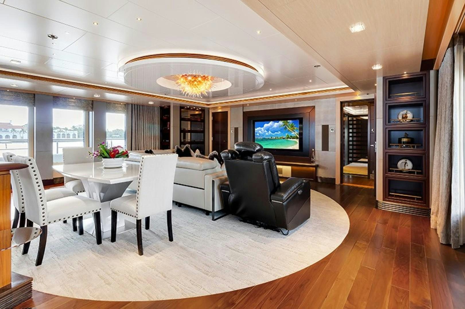 a large living room with a large chandelier aboard QUANTUM OF SOLACE Yacht for Sale
