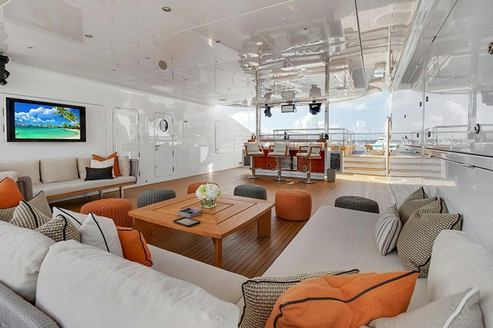 a living room with a large screen aboard QUANTUM OF SOLACE Yacht for Sale