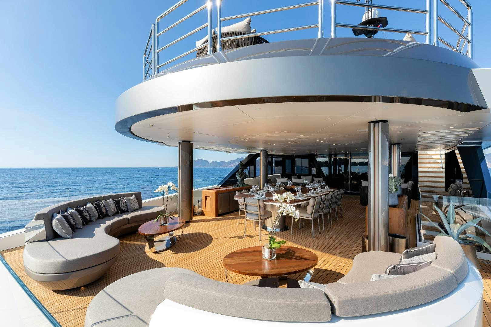 a large white lounge chair next to a large white umbrella on a deck aboard SOLO Yacht for Sale