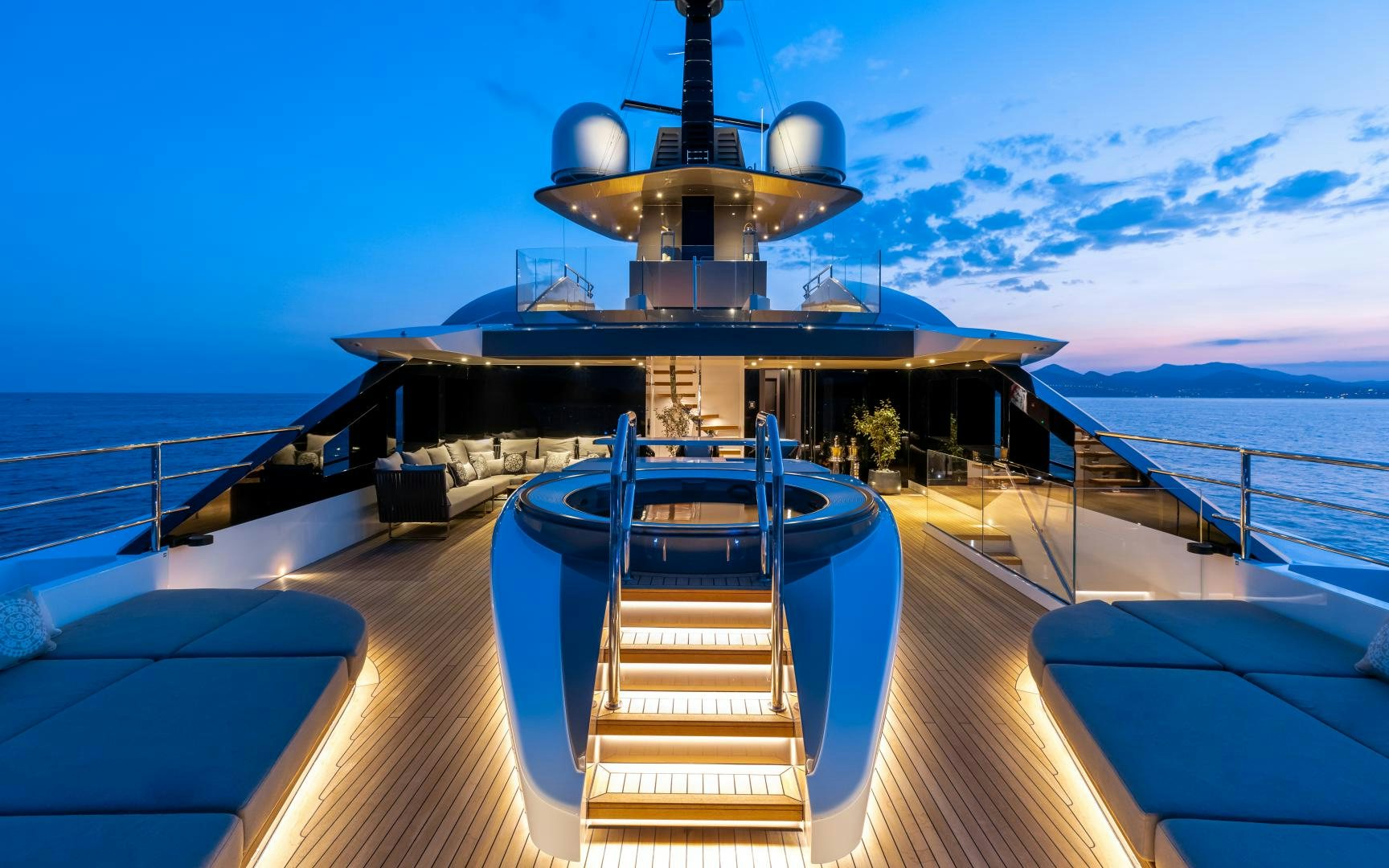 a deck with a large ship on it and a body of water in the background aboard SOLO Yacht for Sale