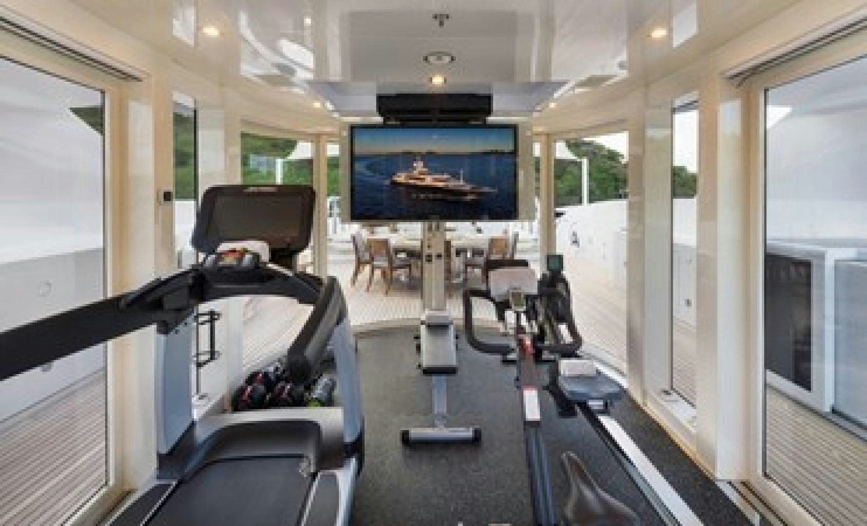 a room with a tv and chairs aboard ANDIAMO Yacht for Sale