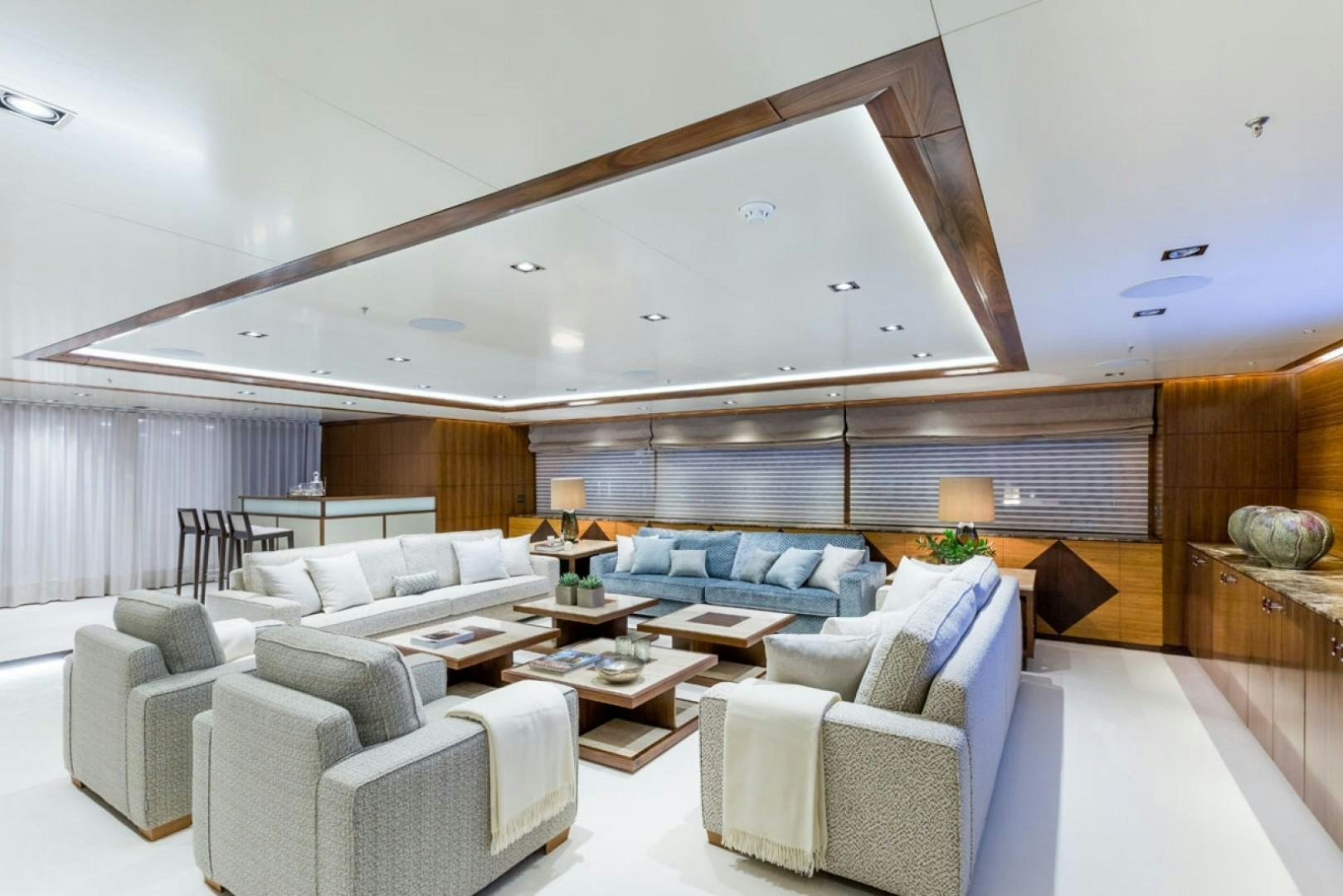 a large living room with white furniture aboard MAYBE Yacht for Sale