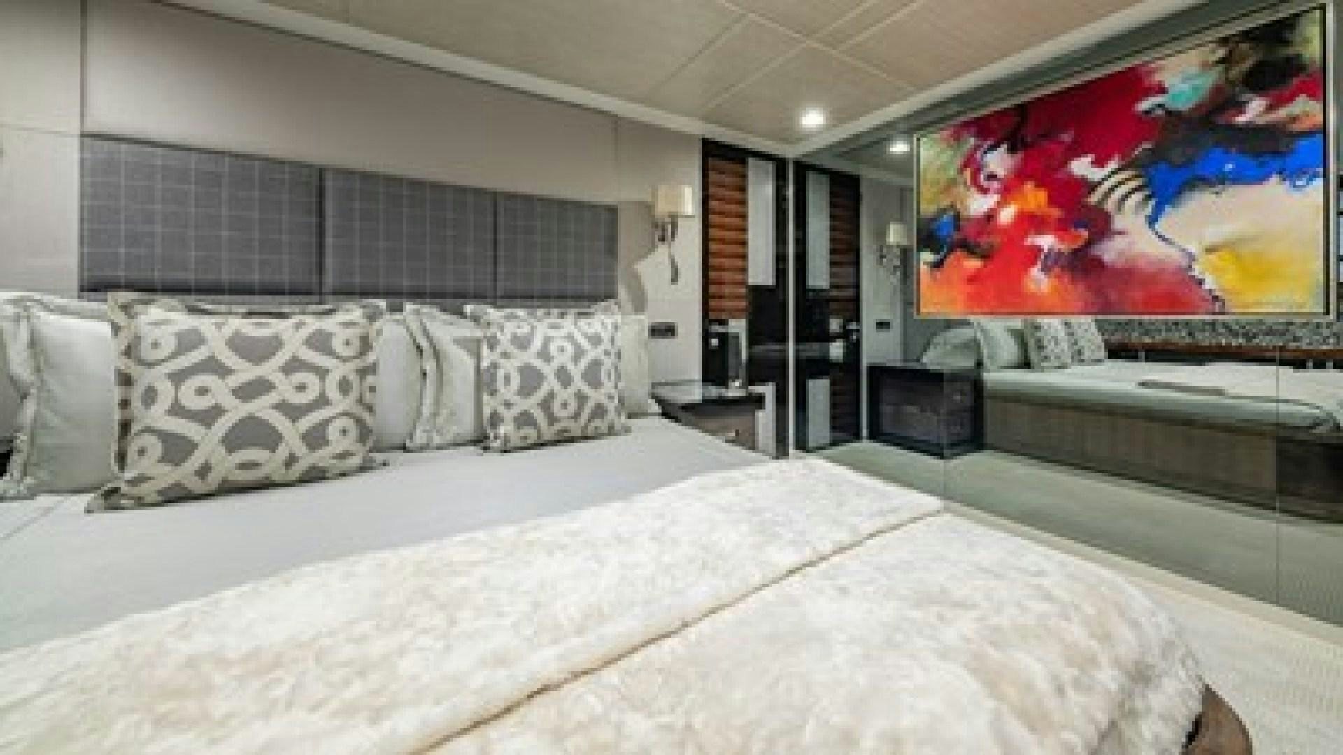 a large bed with a large painting above it aboard HOLDIN' MY OWN Yacht for Sale