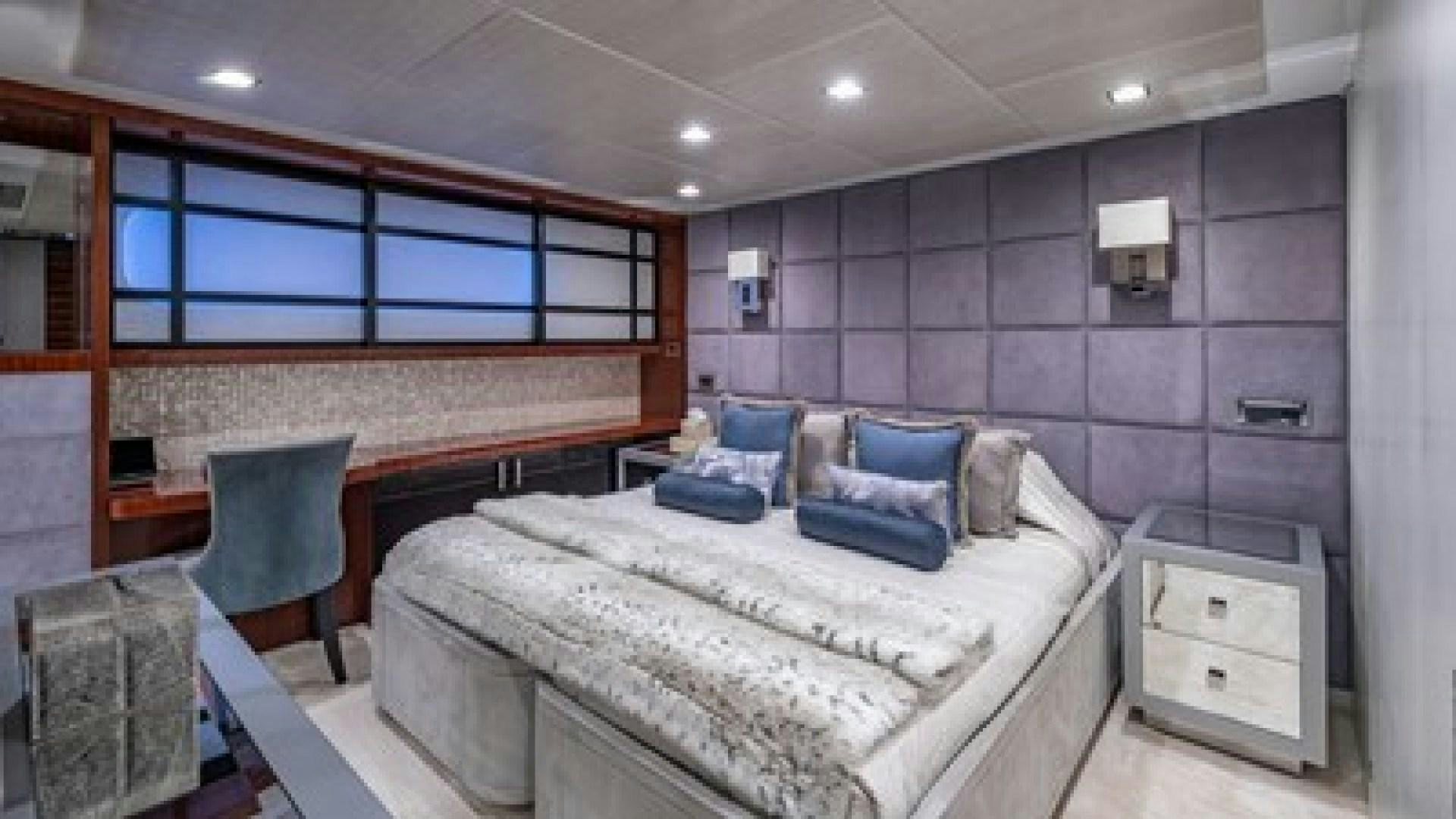 a bedroom with a bed and a chair aboard HOLDIN' MY OWN Yacht for Sale