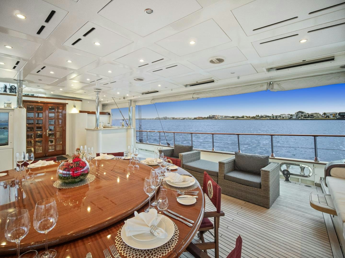 a large room with a table and chairs and a view of the ocean aboard THE LANGLEY Yacht for Sale