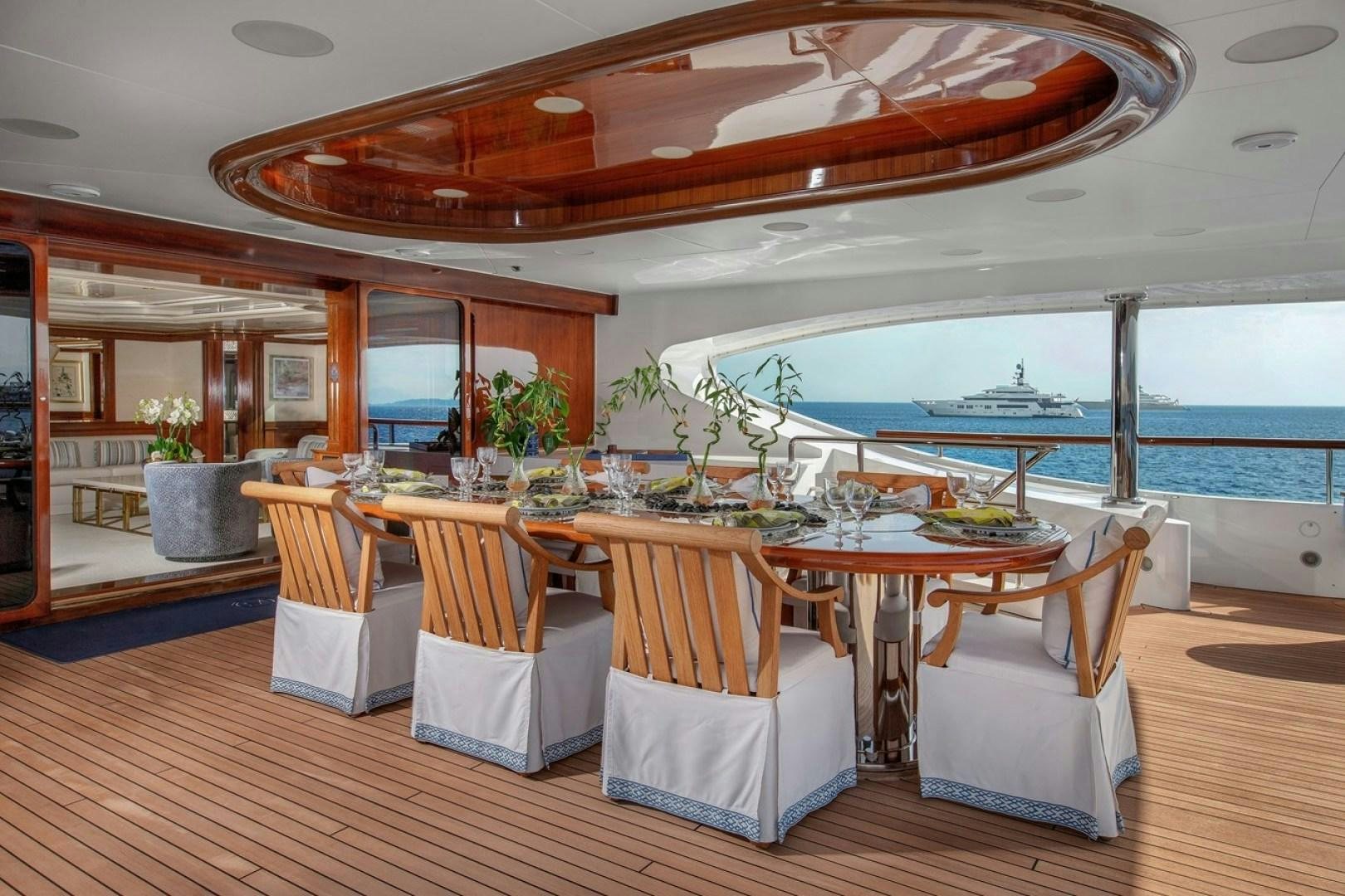 a dining table with chairs and a large window overlooking a body of water aboard NEXT CHAPTER Yacht for Sale