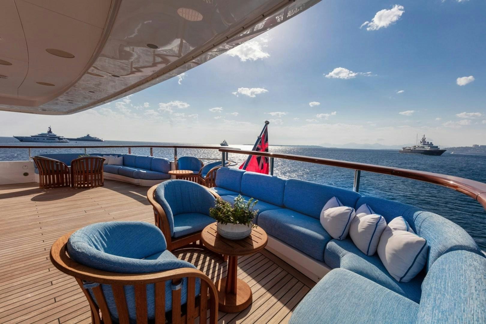 a lounge area with a large blue couch and a large body of water aboard NEXT CHAPTER Yacht for Sale