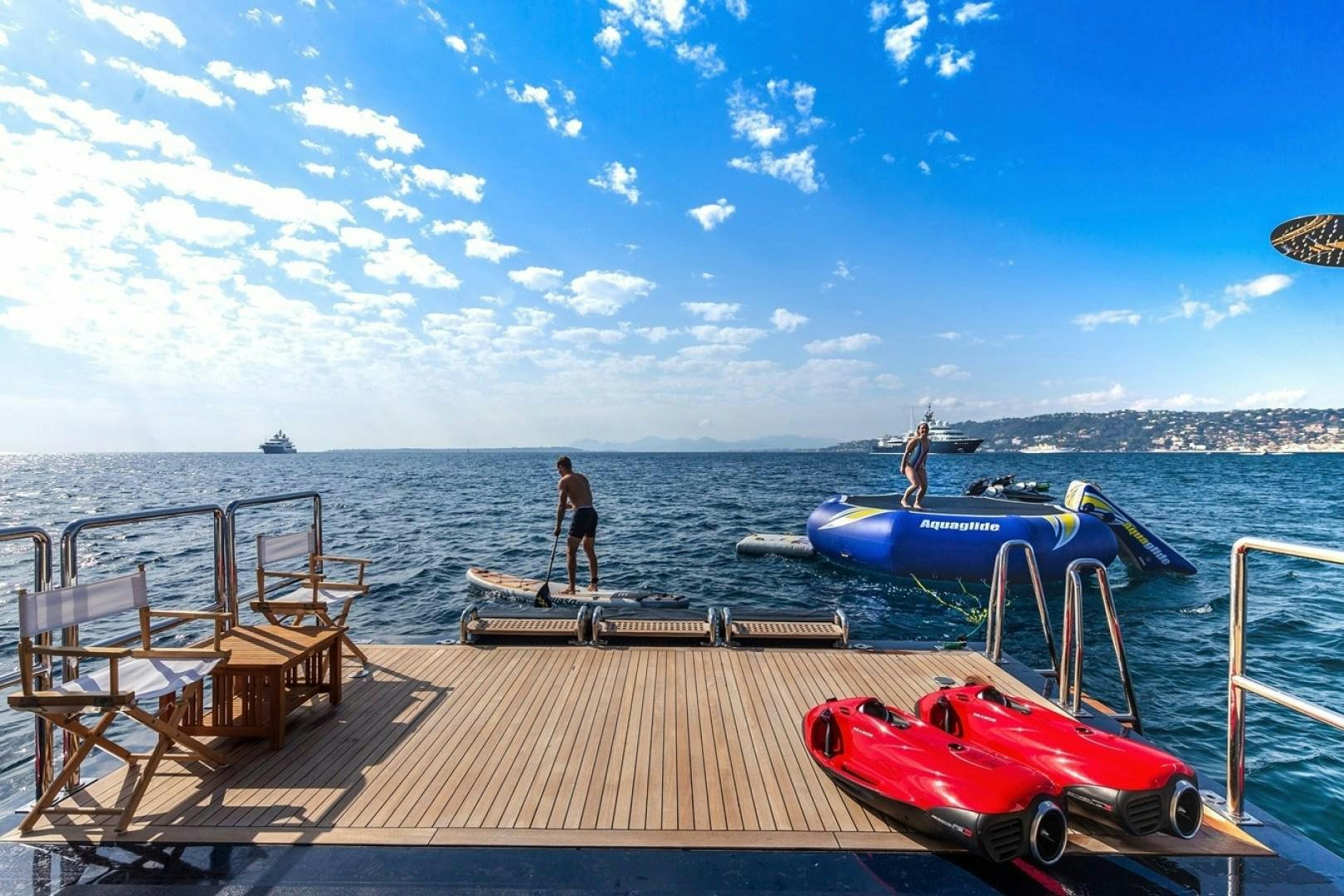 a person standing on a dock next to a boat aboard NEXT CHAPTER Yacht for Sale