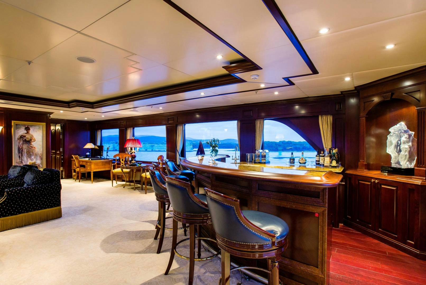 a room with a bar and a table and chairs aboard MUSTIQUE Yacht for Sale