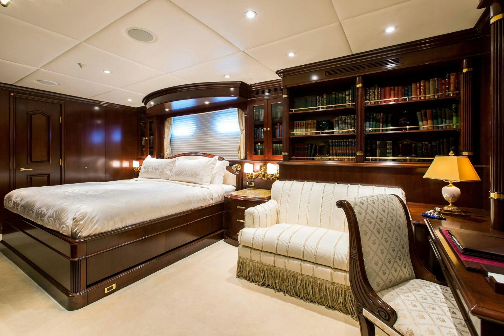 a room with a bed and a book shelf aboard MUSTIQUE Yacht for Sale
