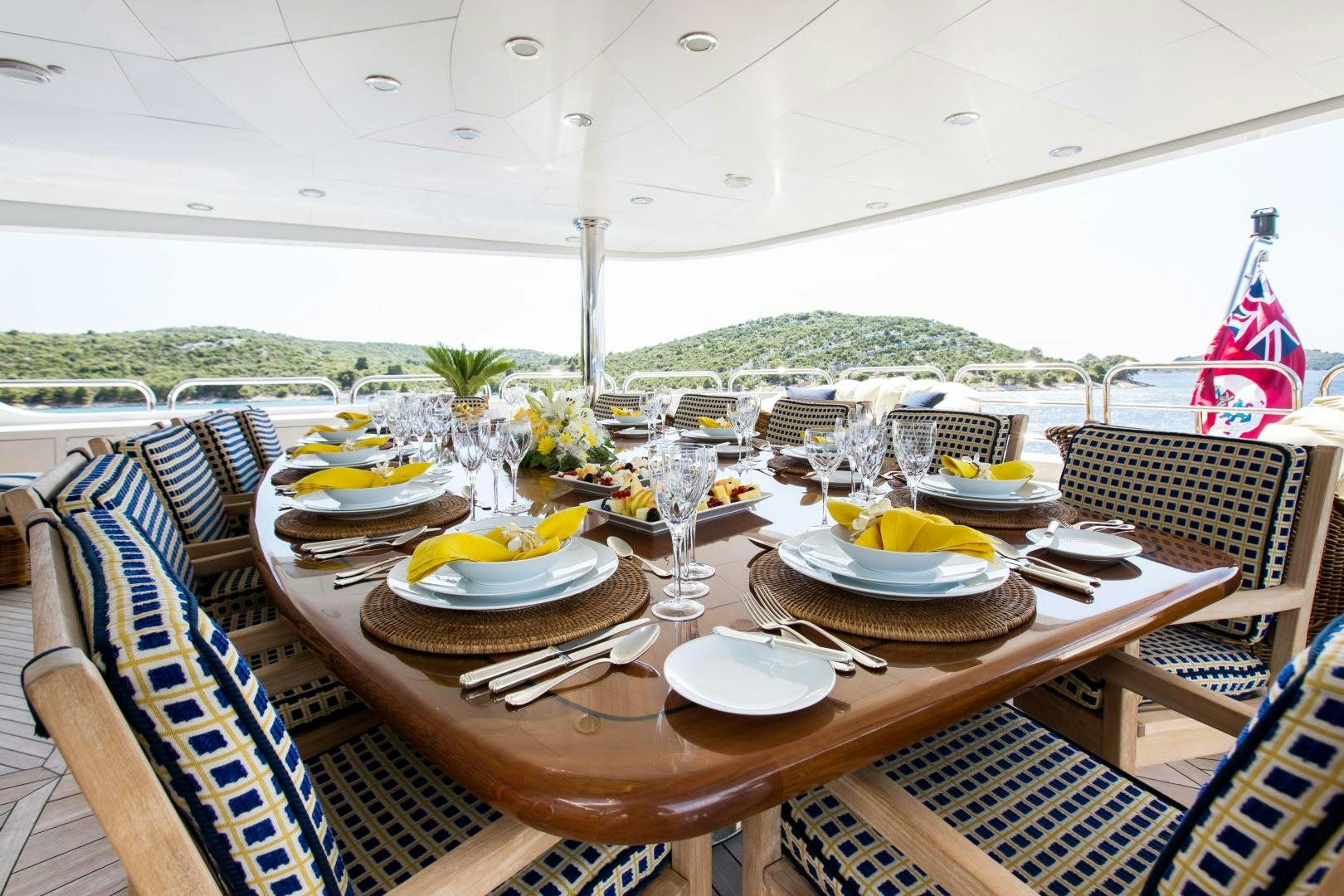 a table with plates and glasses on it aboard MUSTIQUE Yacht for Sale