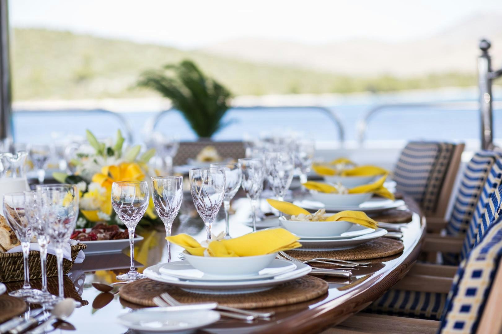 a table set with plates and glasses aboard MUSTIQUE Yacht for Sale