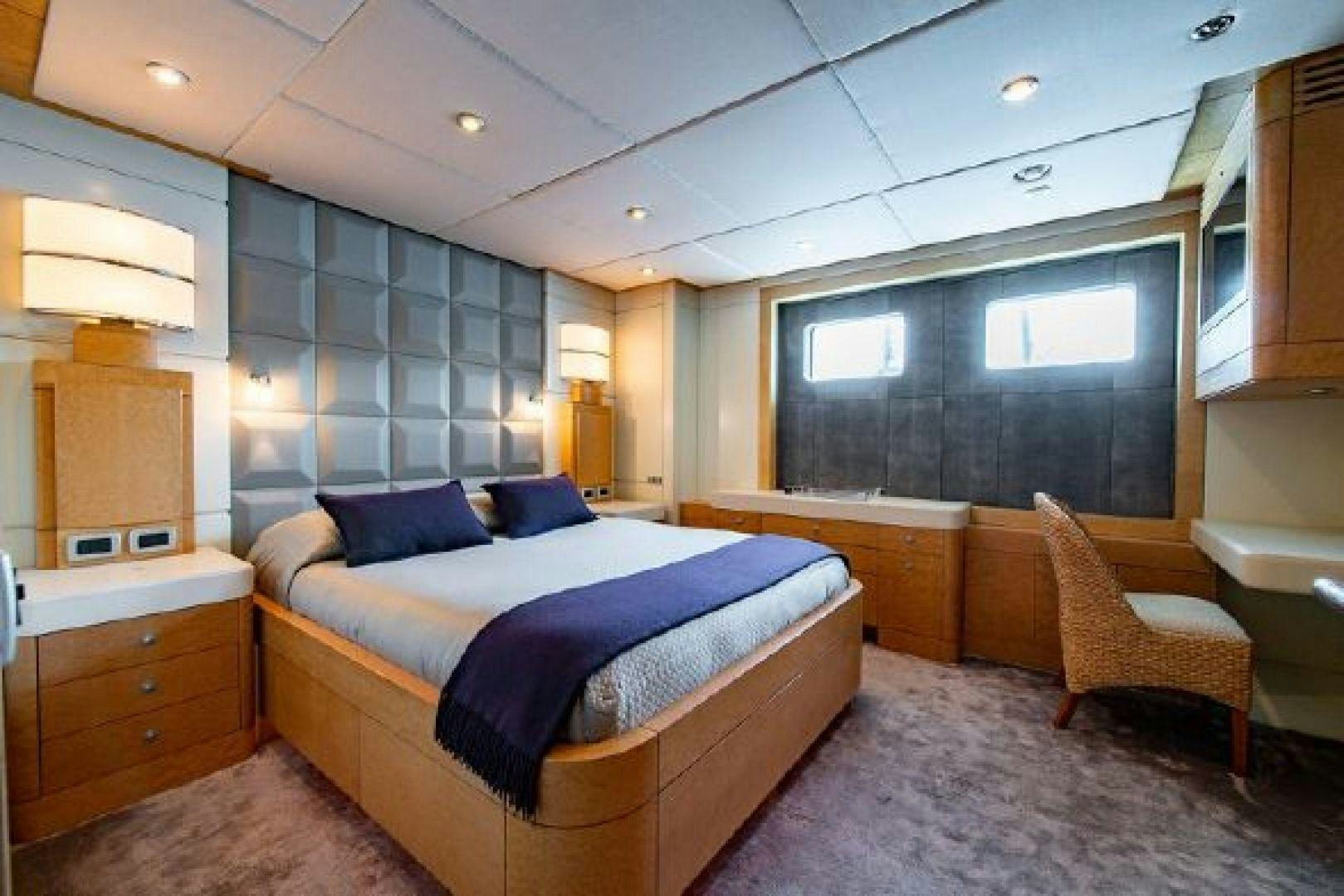 a bedroom with a bed and a chair aboard 174 OCEANFAST MIZU Yacht for Sale