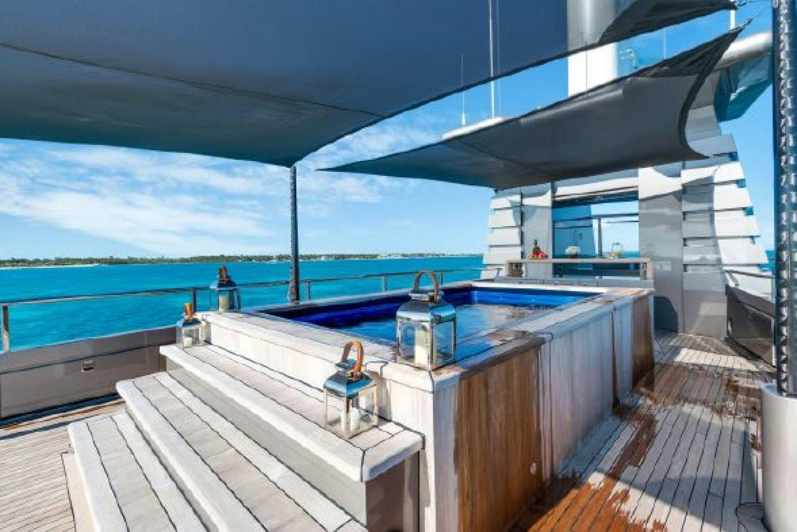 a deck with a large pool and a deck with a view of the ocean aboard 174 OCEANFAST MIZU Yacht for Sale