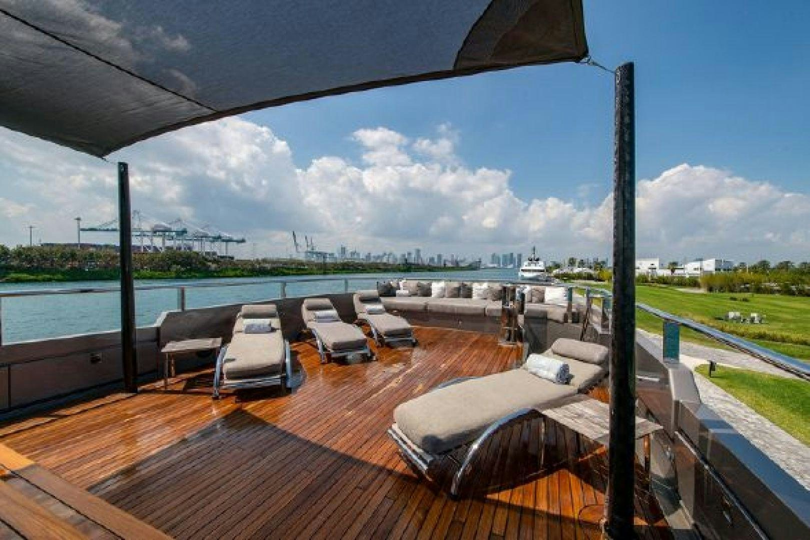 a deck with a view of a lake and a deck with chairs aboard 174 OCEANFAST MIZU Yacht for Sale