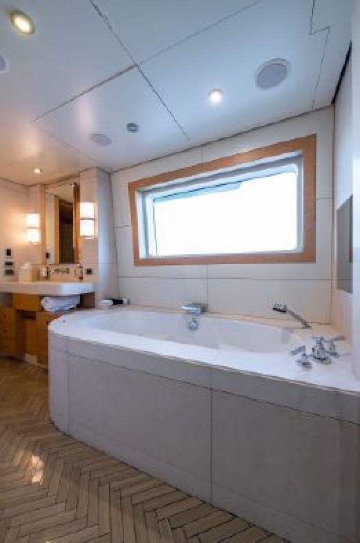 a bathroom with a bathtub and sinks aboard 174 OCEANFAST MIZU Yacht for Sale