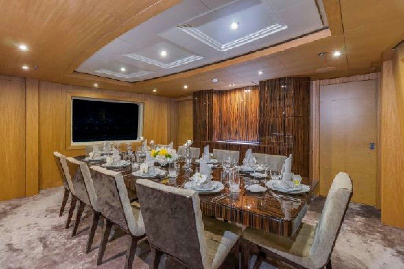 a dining room with a large wood wall aboard 174 OCEANFAST MIZU Yacht for Sale