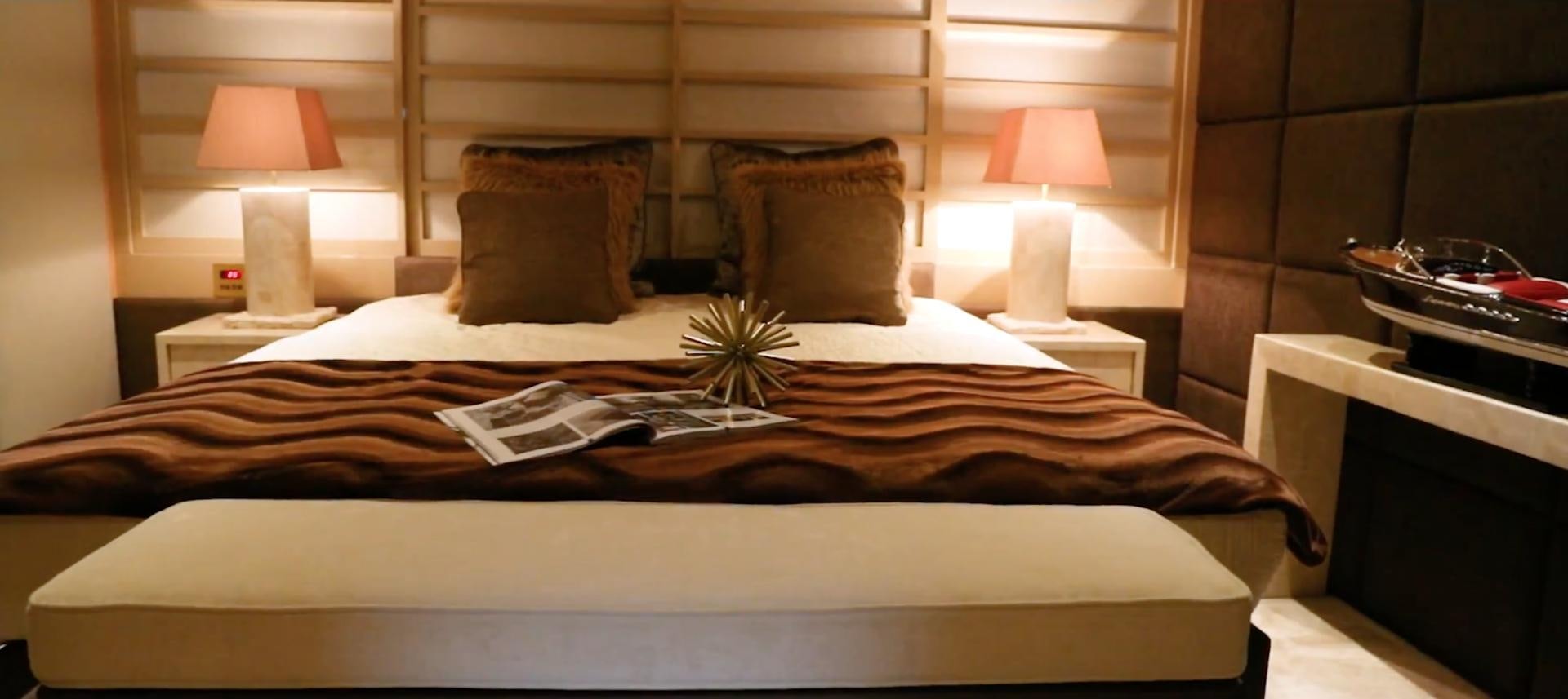 a bed with a lamp and pillows aboard ANNA J Yacht for Sale