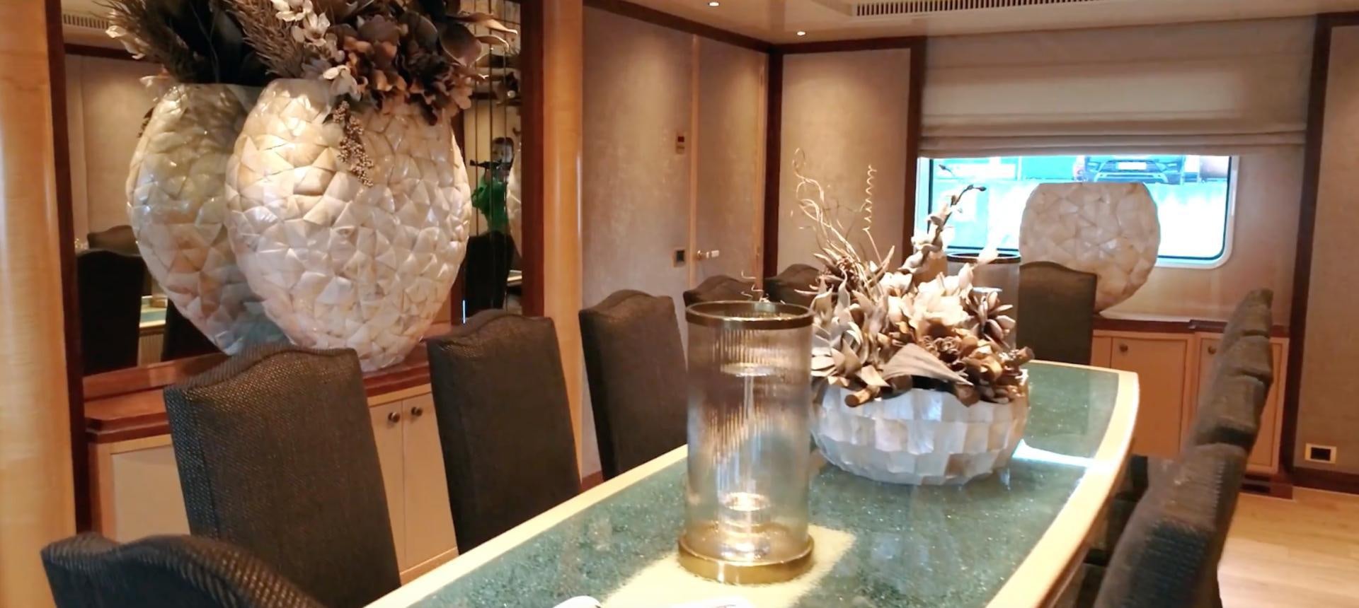 a glass table with a vase and a vase with flowers on it aboard ANNA J Yacht for Sale
