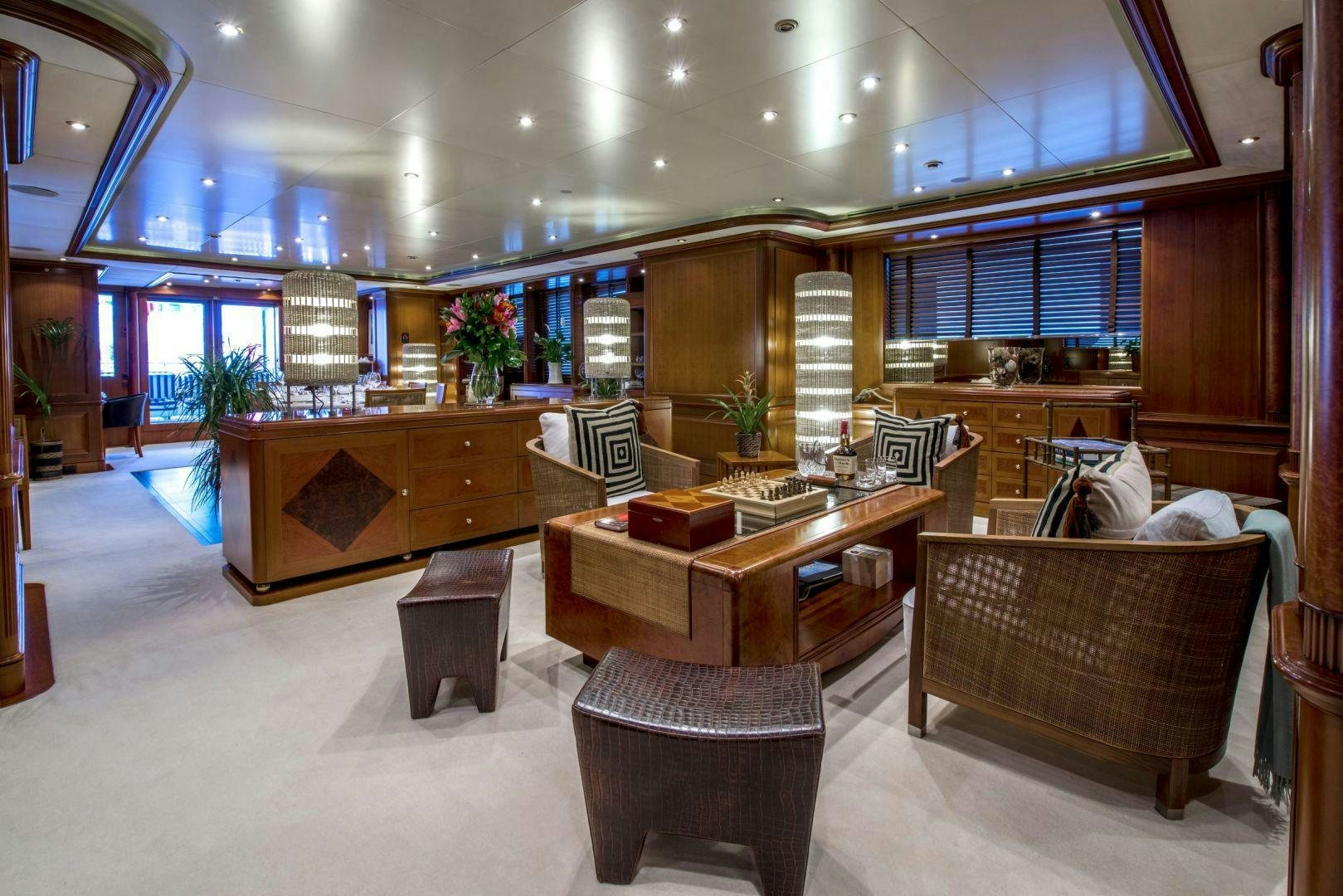 a large living room with a bar and a table aboard JO I Yacht for Charter
