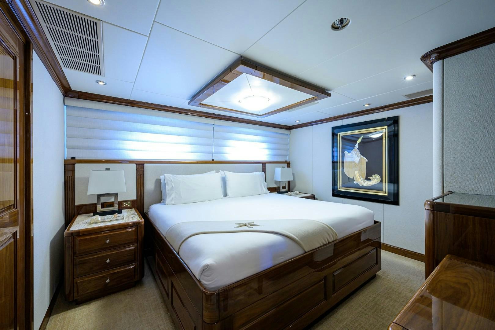 a bedroom with a bed and a dresser aboard REMEMBER WHEN Yacht for Sale
