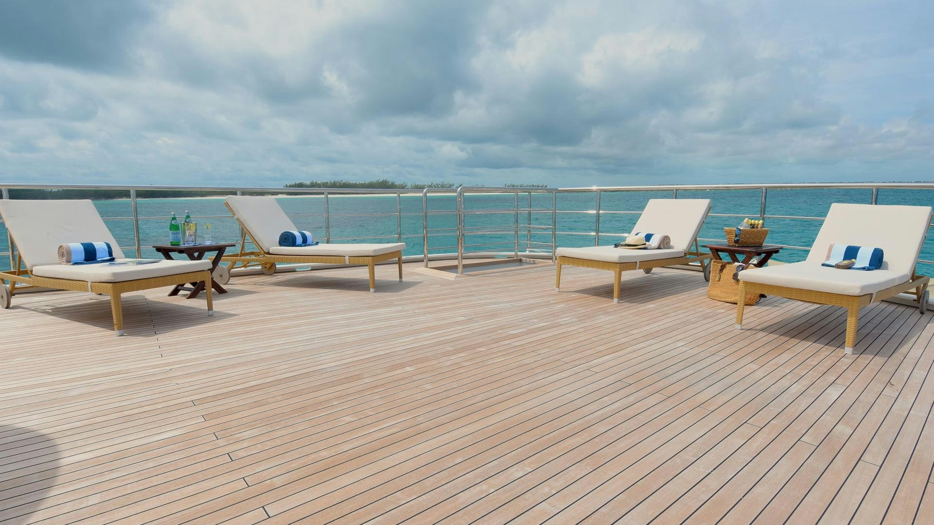 a deck with chairs and tables on it aboard OMNIA Yacht for Sale