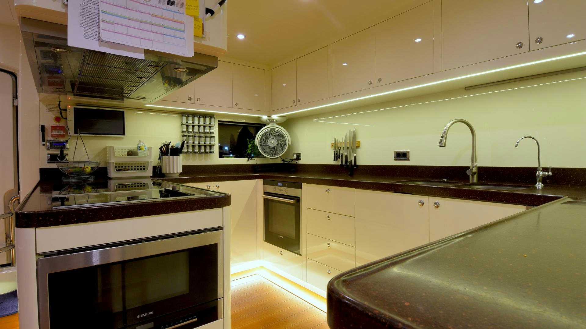 a kitchen with white cabinets aboard OMNIA Yacht for Sale