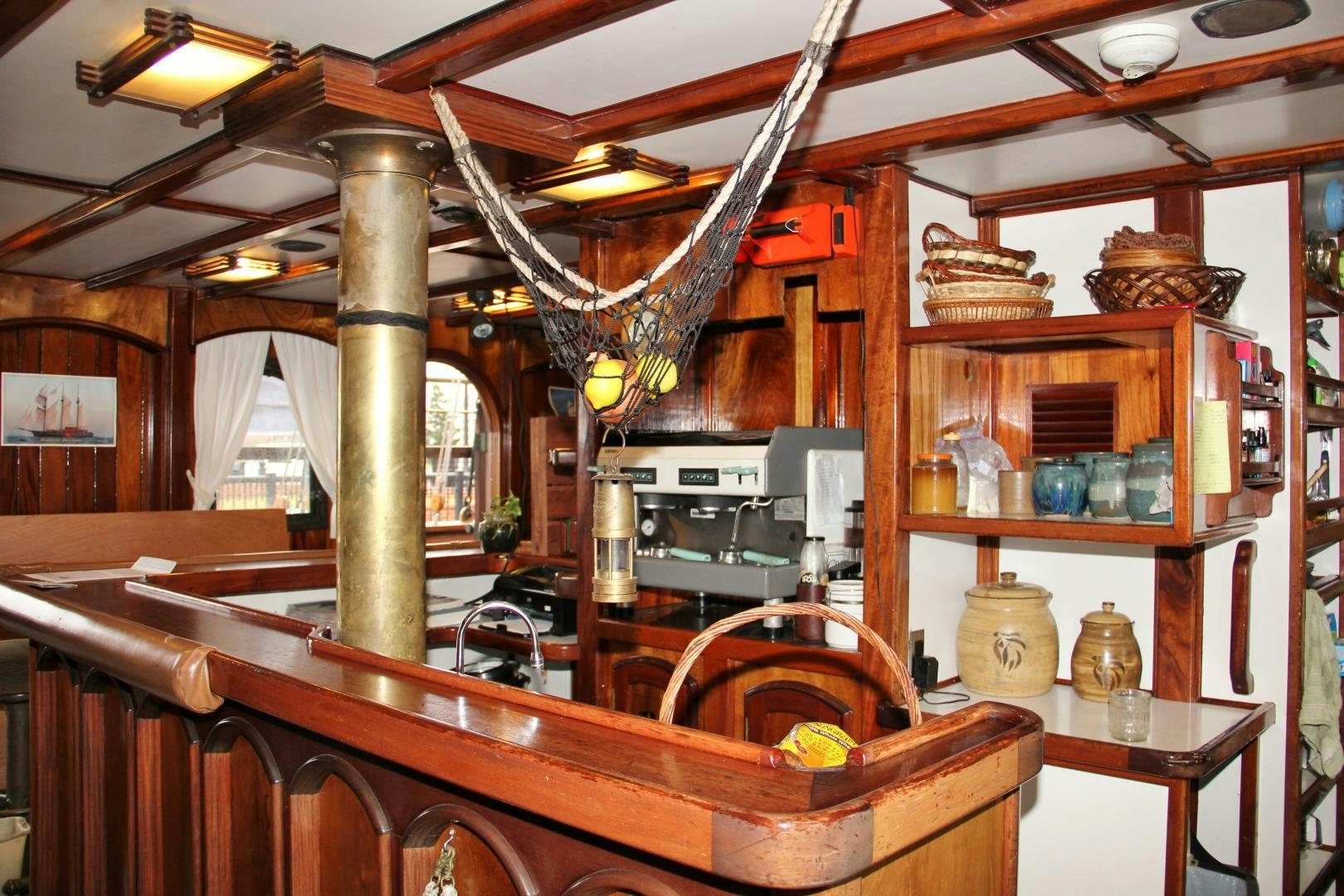 a wooden kitchen with a large wooden table and a large wood stove aboard PEACEMAKER Yacht for Sale