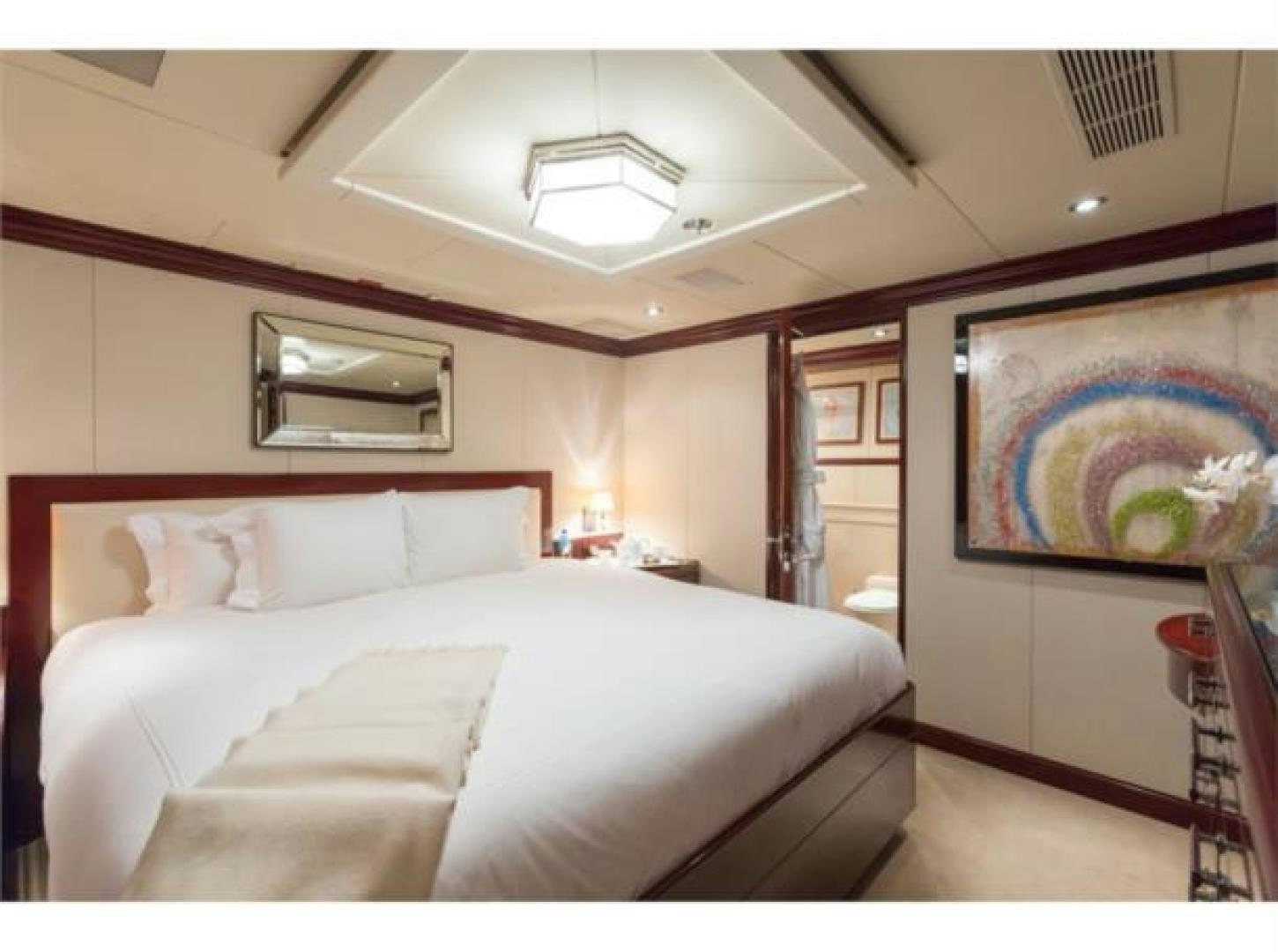 a bedroom with a bed and a television on the wall aboard LADY JOY Yacht for Sale