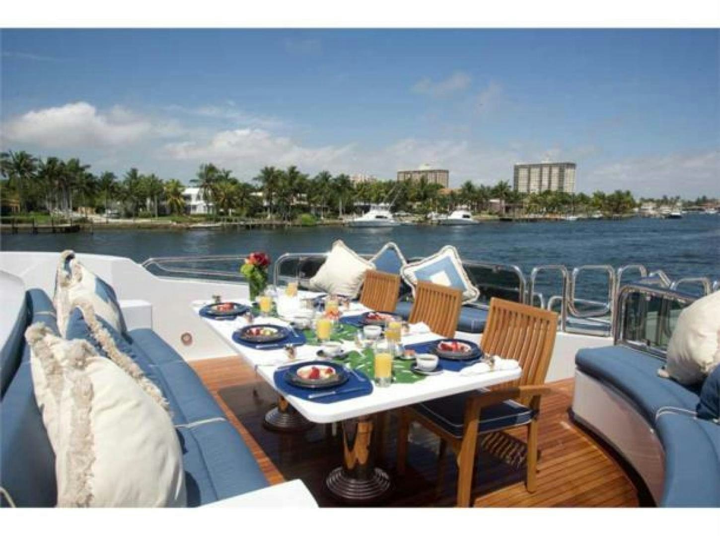 a table with chairs on it next to a body of water aboard LADY JOY Yacht for Sale