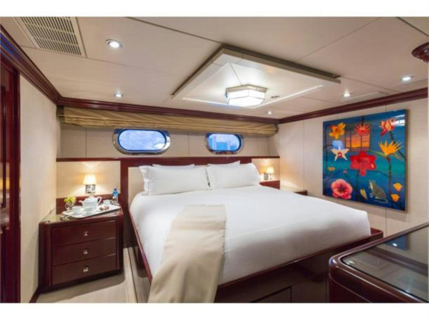 a bedroom with a bed and a window aboard LADY JOY Yacht for Sale