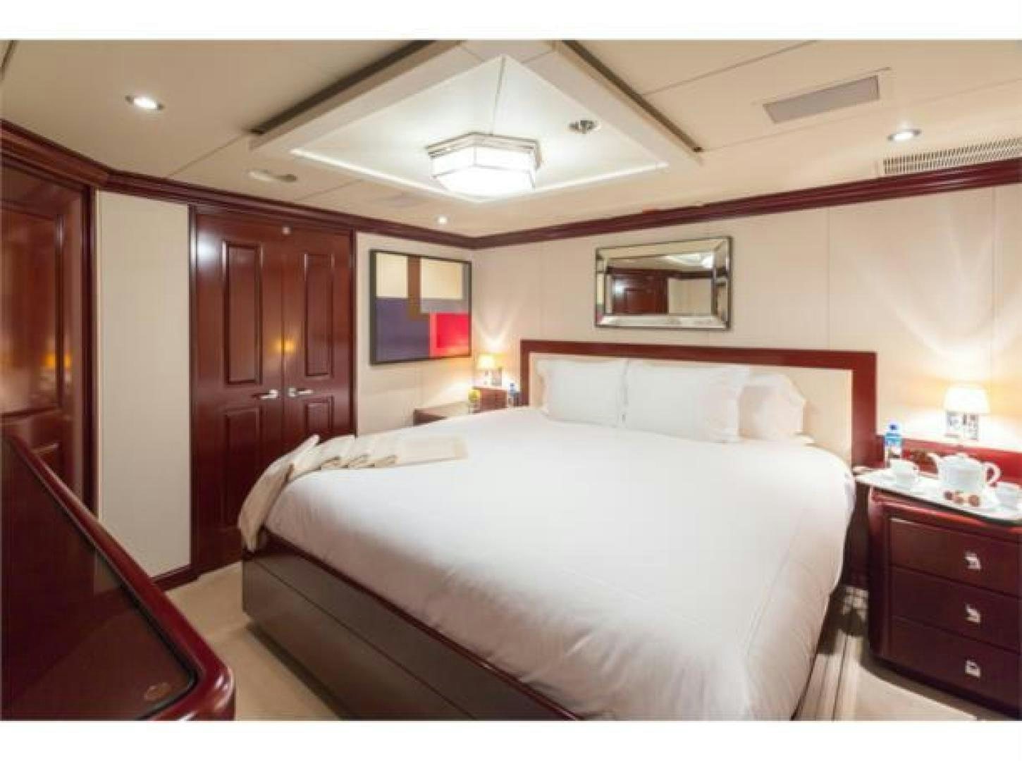 a bedroom with a bed and a television aboard LADY JOY Yacht for Sale