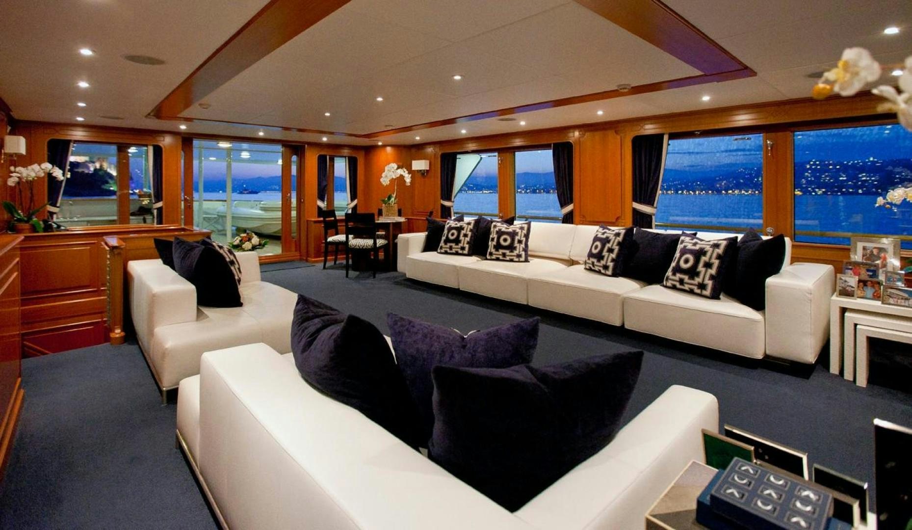 a living room with a large white couch and a large window aboard AUDACIA Yacht for Sale