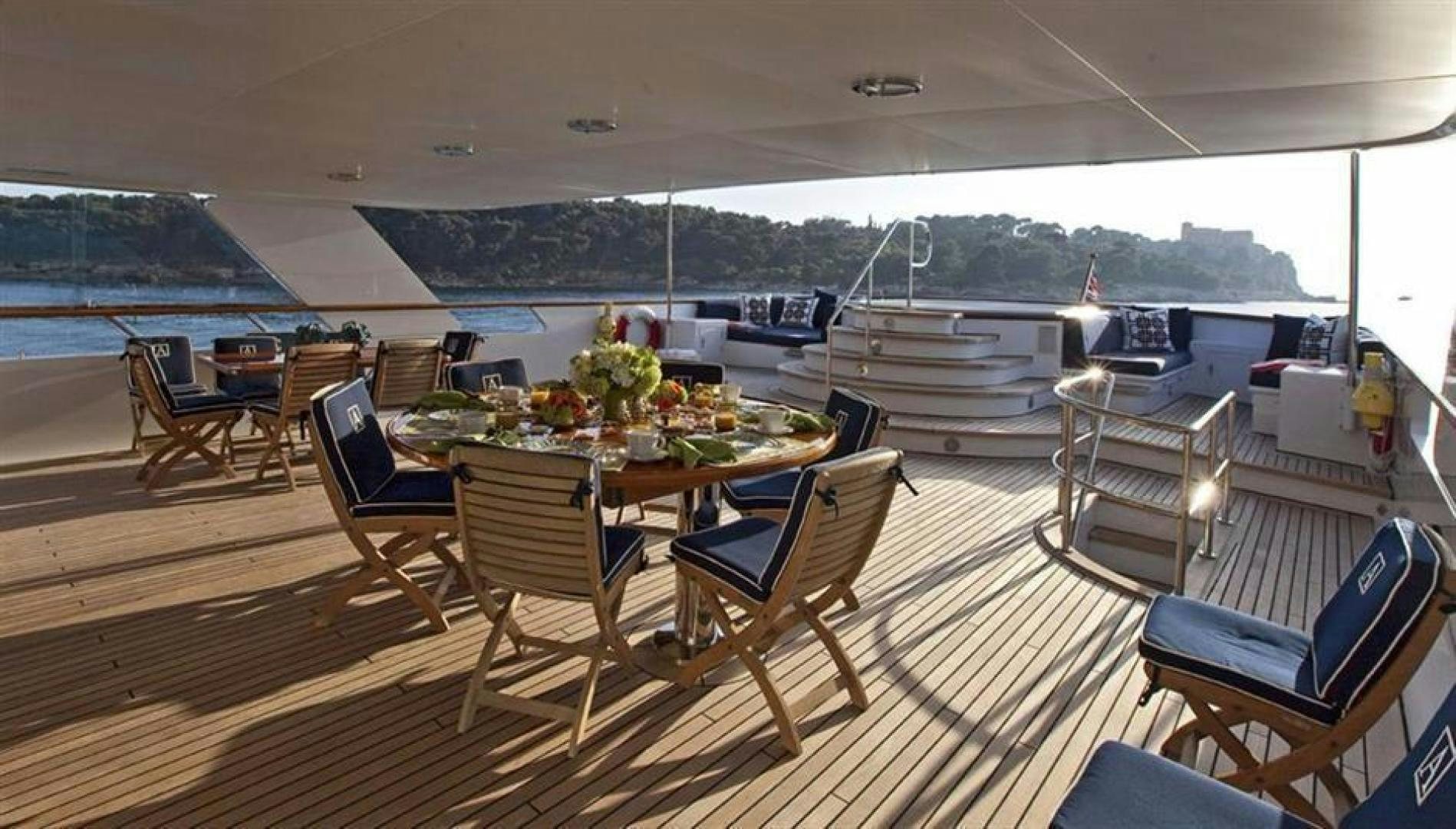 a deck with a table and chairs aboard AUDACIA Yacht for Sale